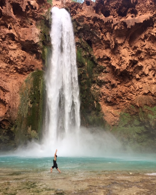 A person standing in front of a waterfall